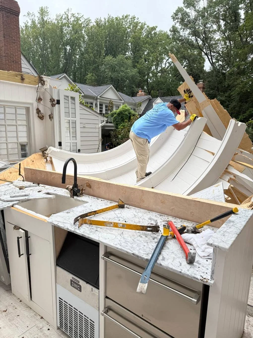Crew member demolishing a curved outdoor structure