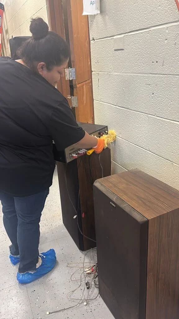 Crew member doing on-site contents cleaning of a stereo amplifier