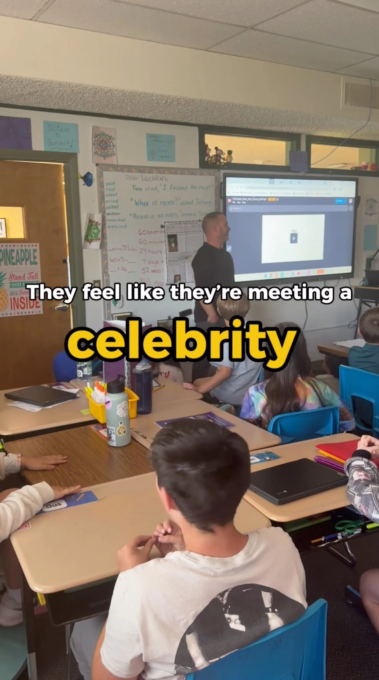 Jeff the teacher stands at the front of a classroom of 3rd and 4th graders. Text on screen reads "They feel like they're meeting a celebrity"