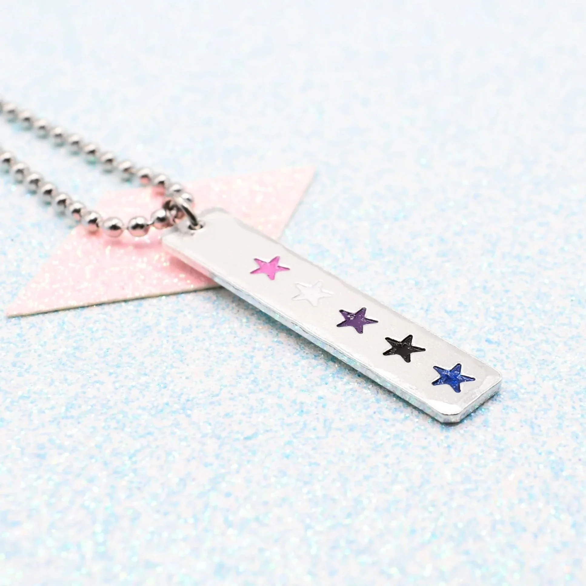 Vertical bar necklace featuring genderfluid flag enamel stars