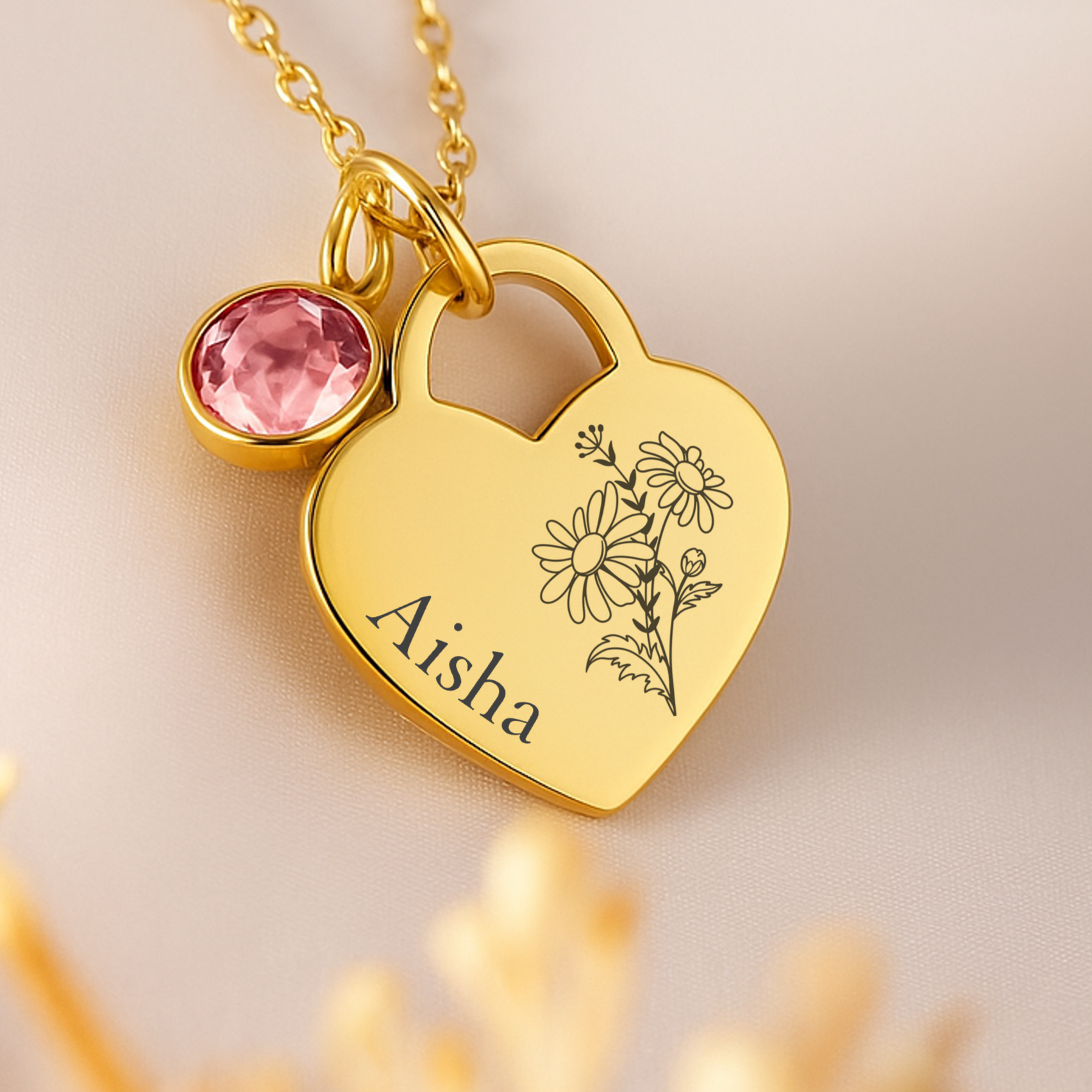 A gold heart featuring a birth flower and personalised name of choice