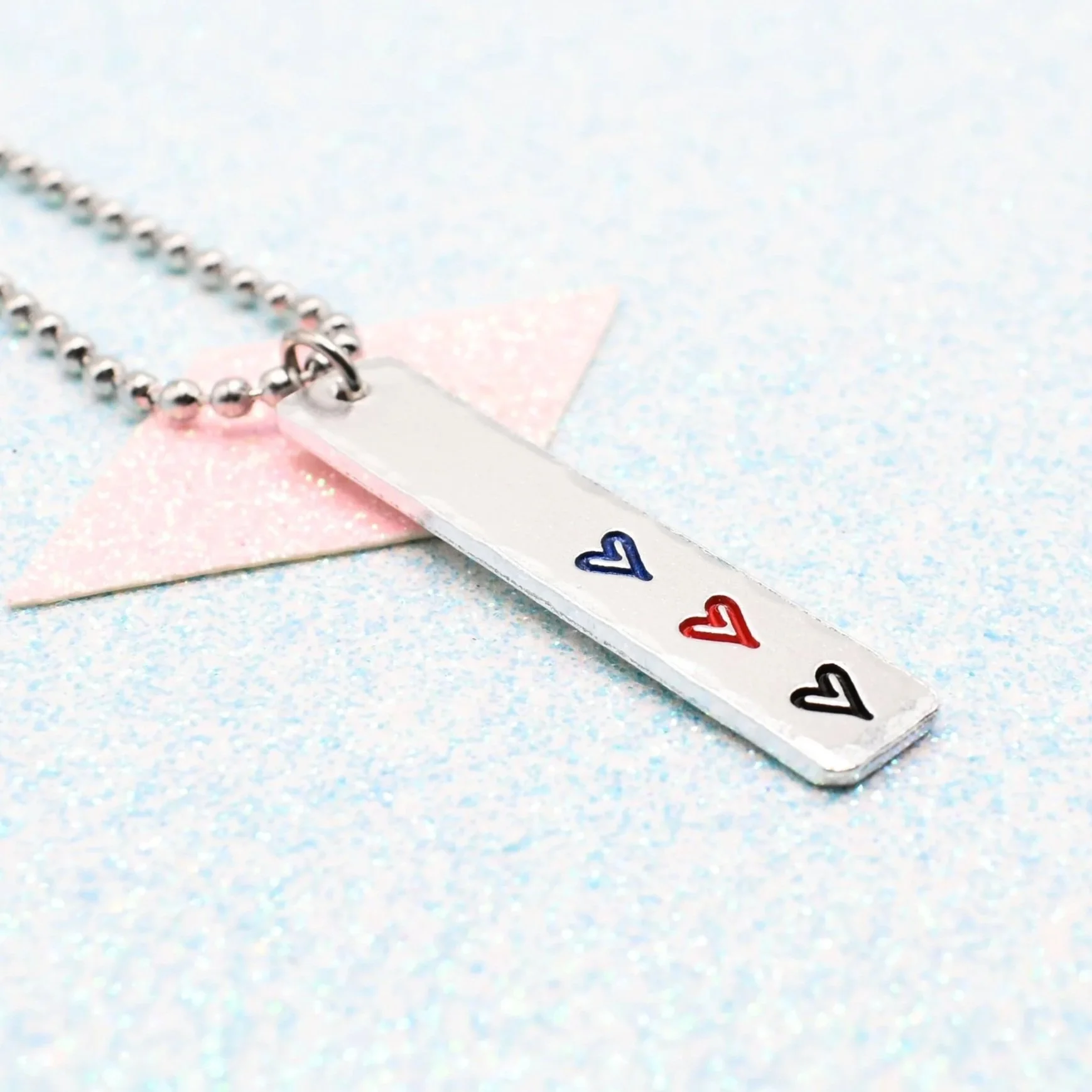 Vertical bar necklace featuring polyamory flag enamel hearts blue red black