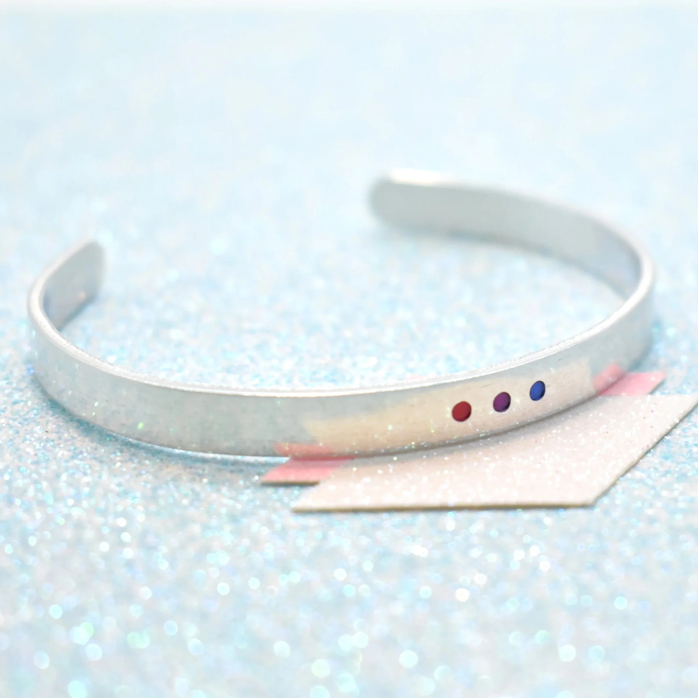 Adjustable cuff bracelet featuring bisexual flag colours pink purple blue