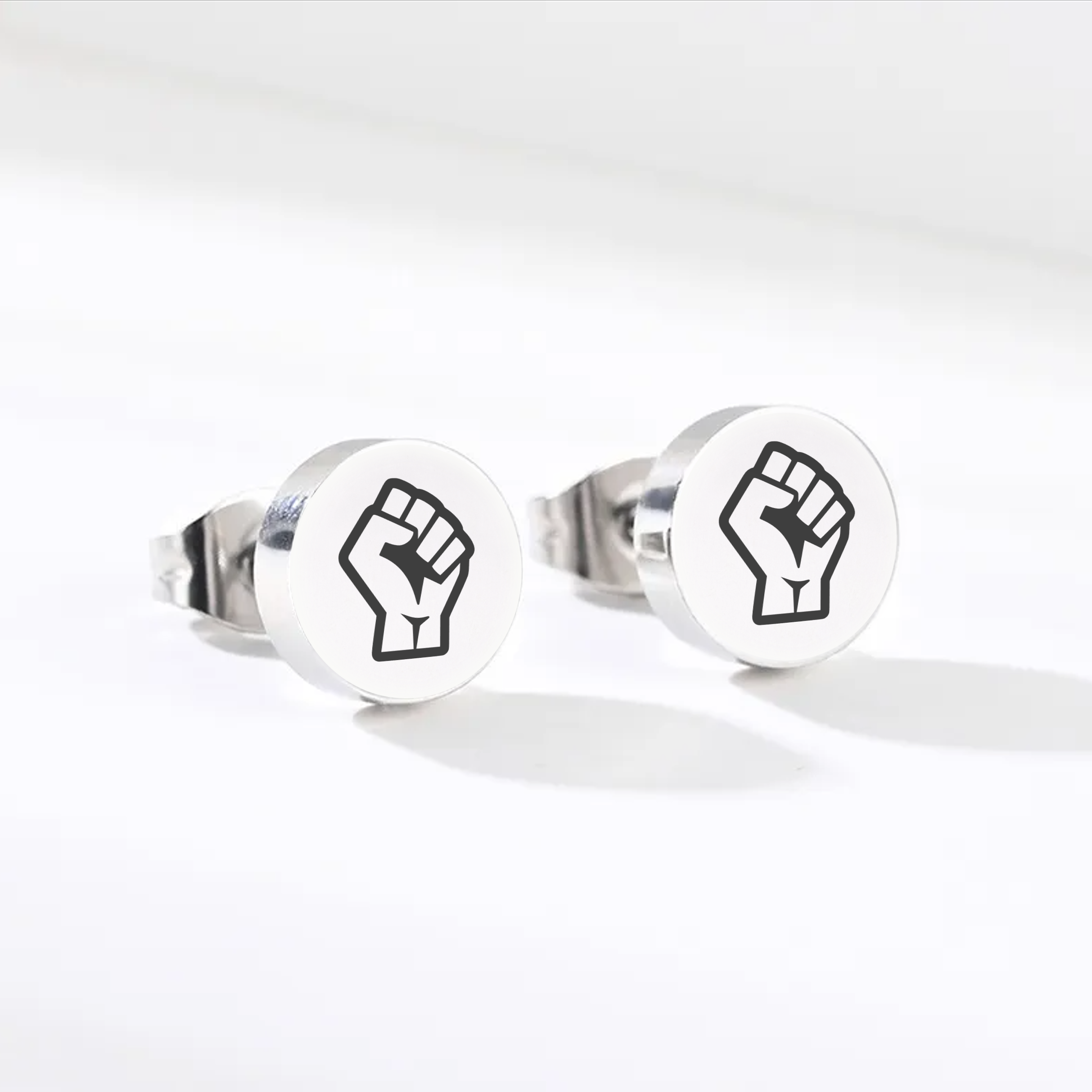 Silver stainless steel protest earrings engraved with fist symbol