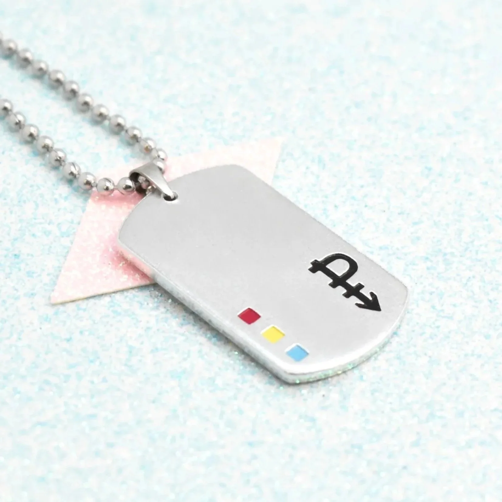 Close-up of pansexual pride jewellery with pride symbol on glitter background