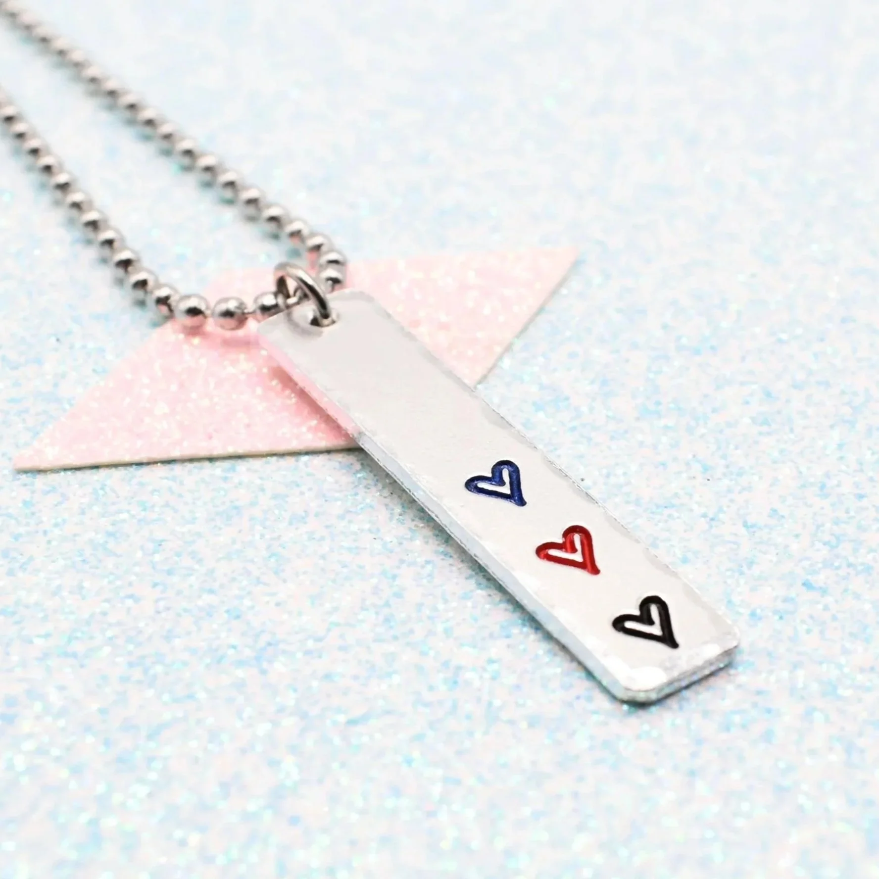 Hand stamped enamelled polyamory pride necklace with heart pendant