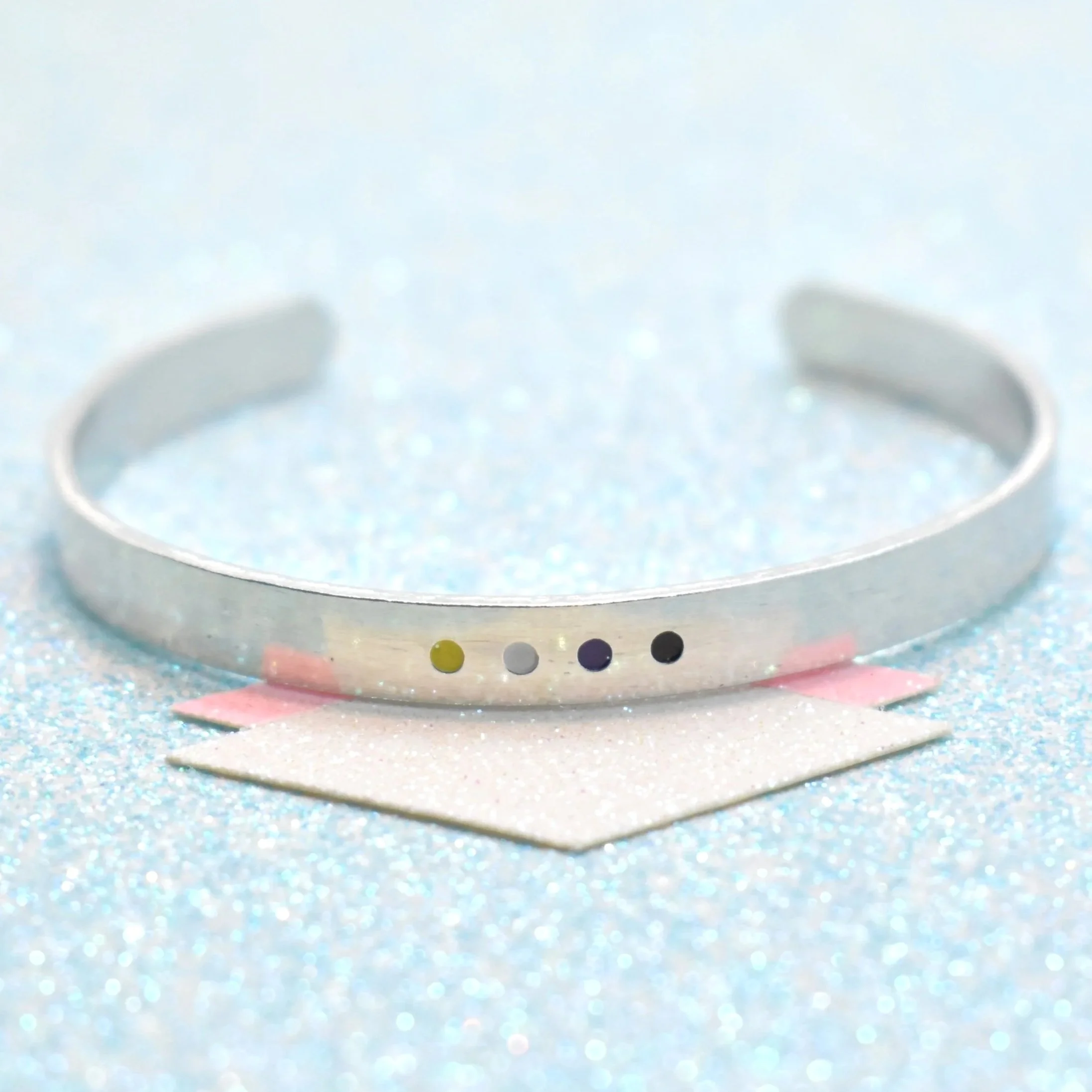 Adjustable cuff bracelet featuring non-binary flag colours yellow white purple black