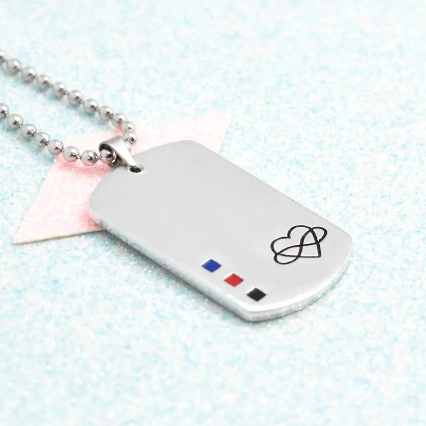 Personalised dog tag necklace featuring polyamorous pride colours on glitter background
