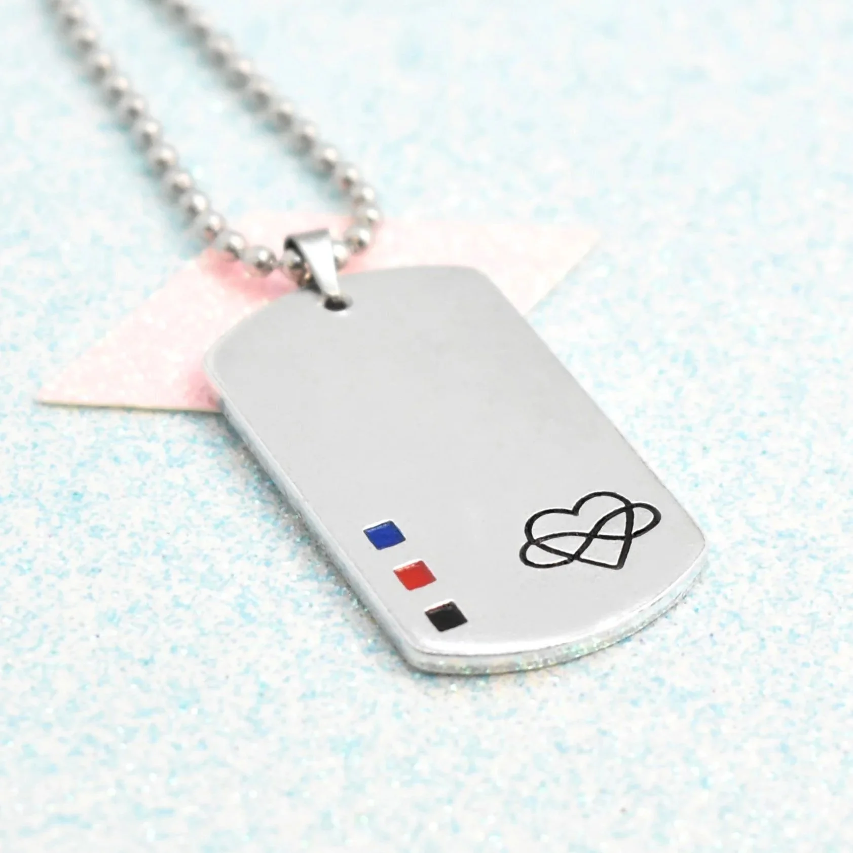 Close-up of polyamorous pride necklace with infinity heart symbol and enamel flag accents