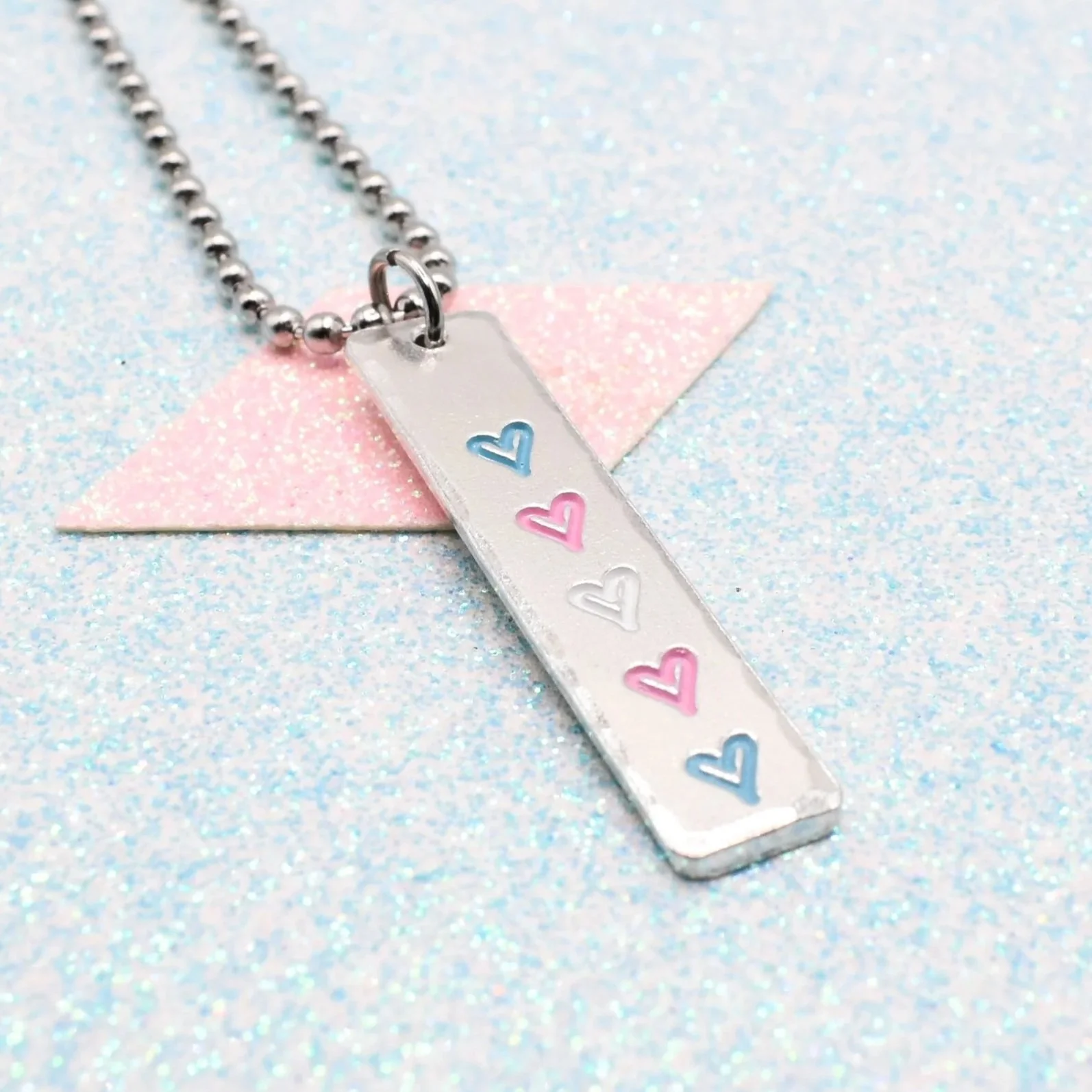 Vertical bar necklace featuring transgender flag enamel hearts blue pink white