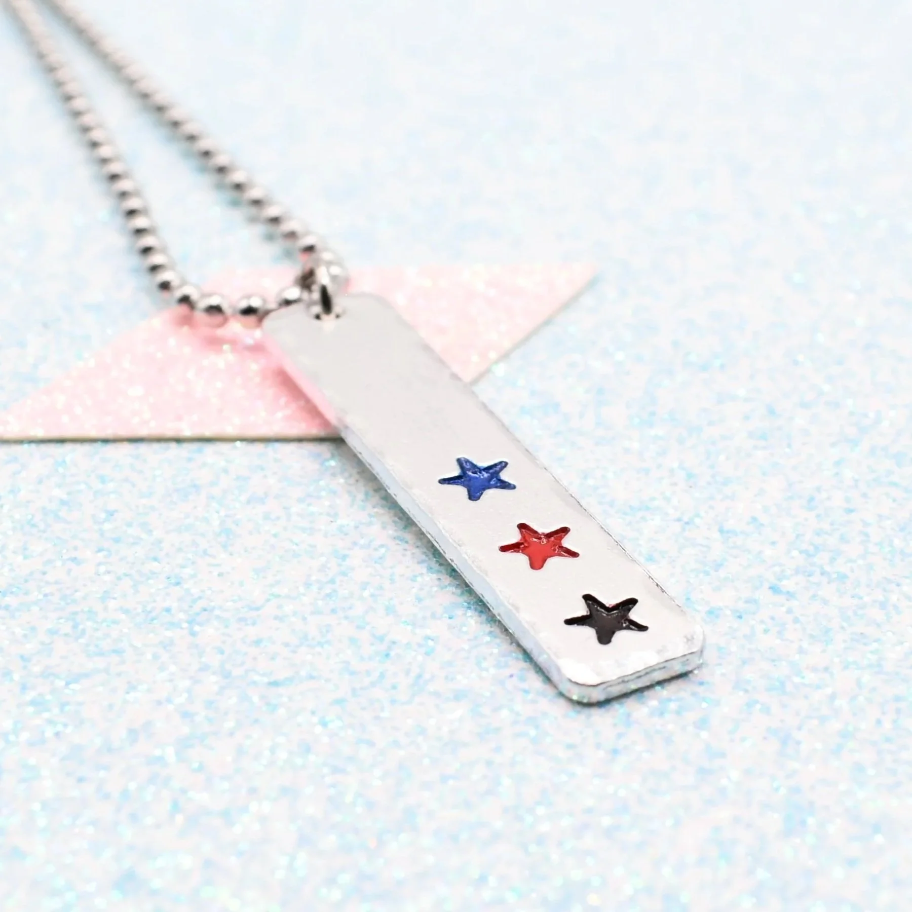 Hand stamped enamelled polyamory pride necklace with star pendant