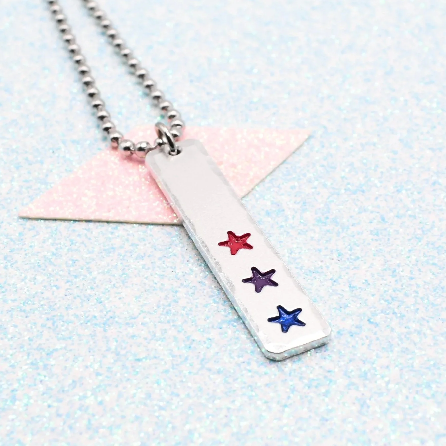 Vertical bar necklace featuring bisexual flag enamel stars pink purple blue
