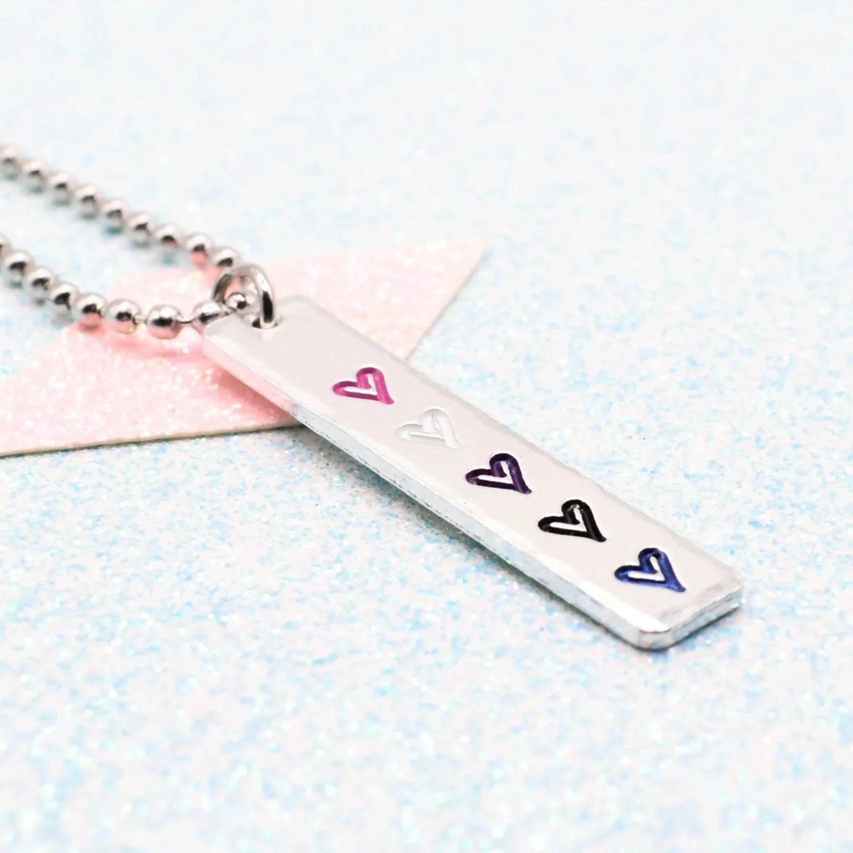 Hand stamped enamelled genderfluid pride necklace with heart pendant