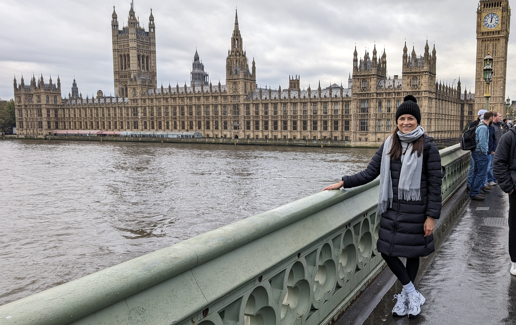 Woman standing on the bridge in front of the Big Ben in London.
