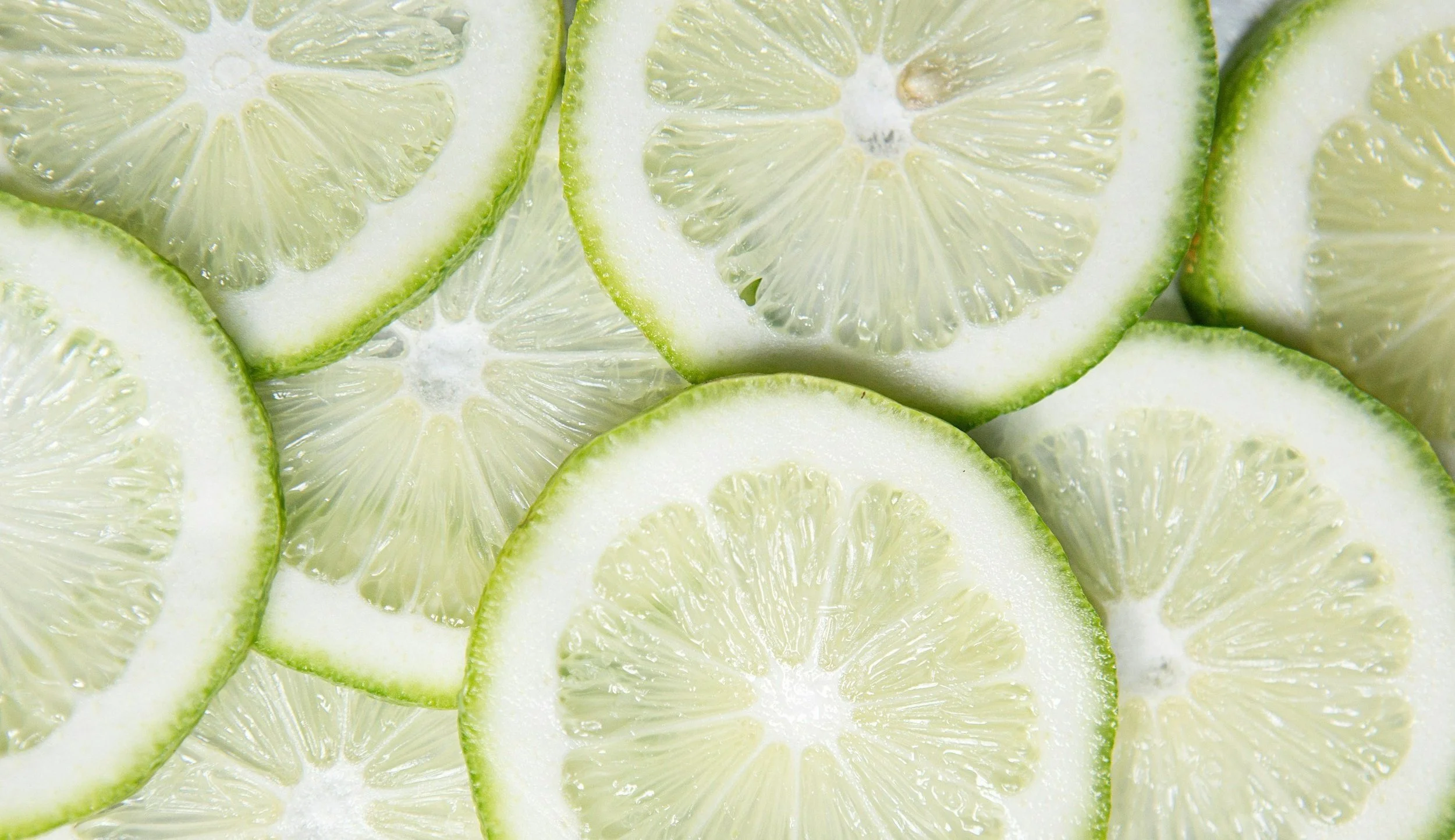 Close-up of sliced lime and lemon pieces showing their interior texture and juice-filled segments.