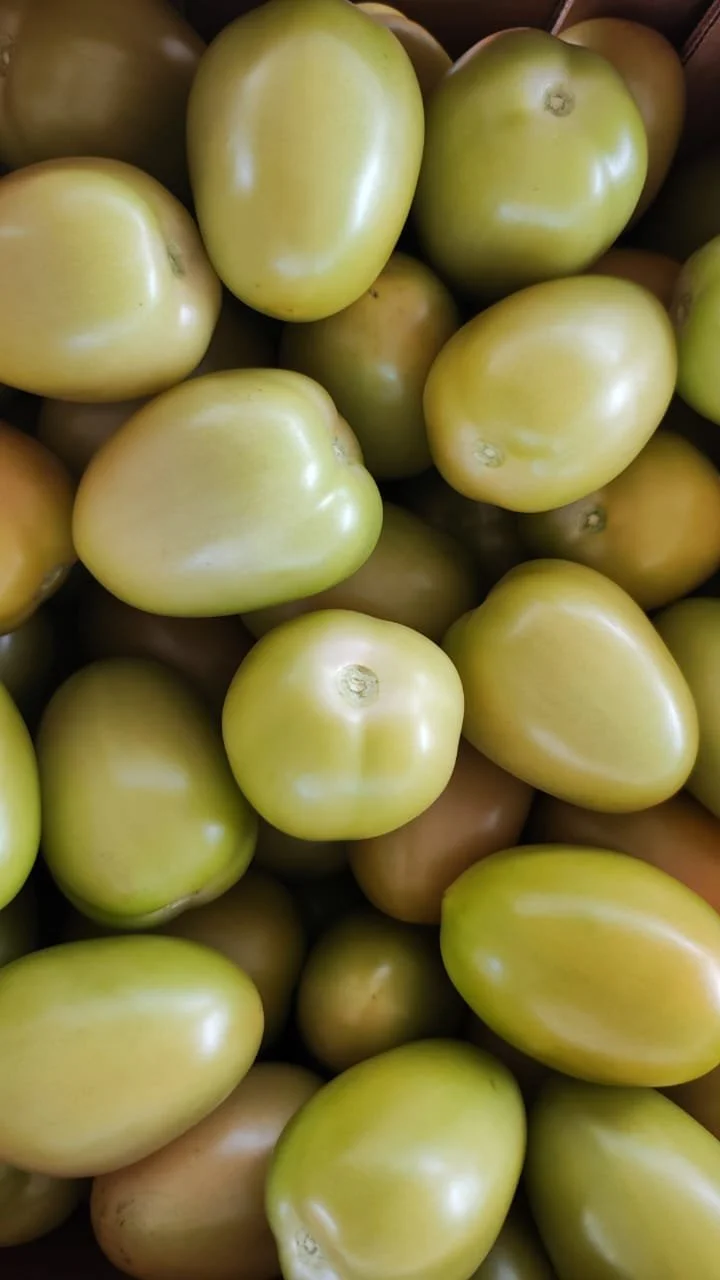 Tomates verdes en un cajón de supermercado.