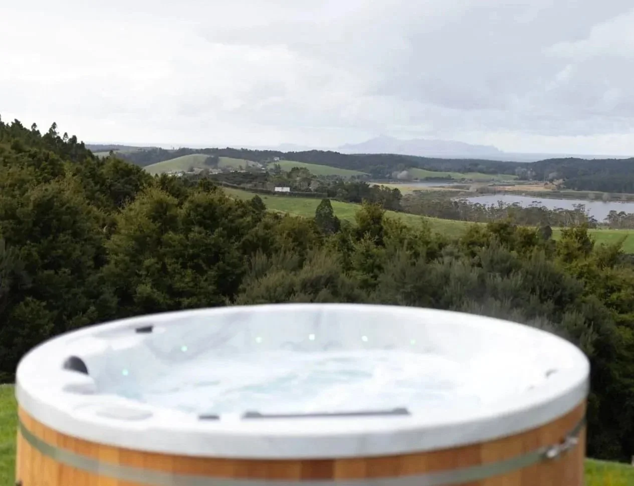 Close-up of spa pool with jets at Ocean View Te Arai, overlooking native trees and lakes to the Pacific Ocean and Hen Island in the distance.