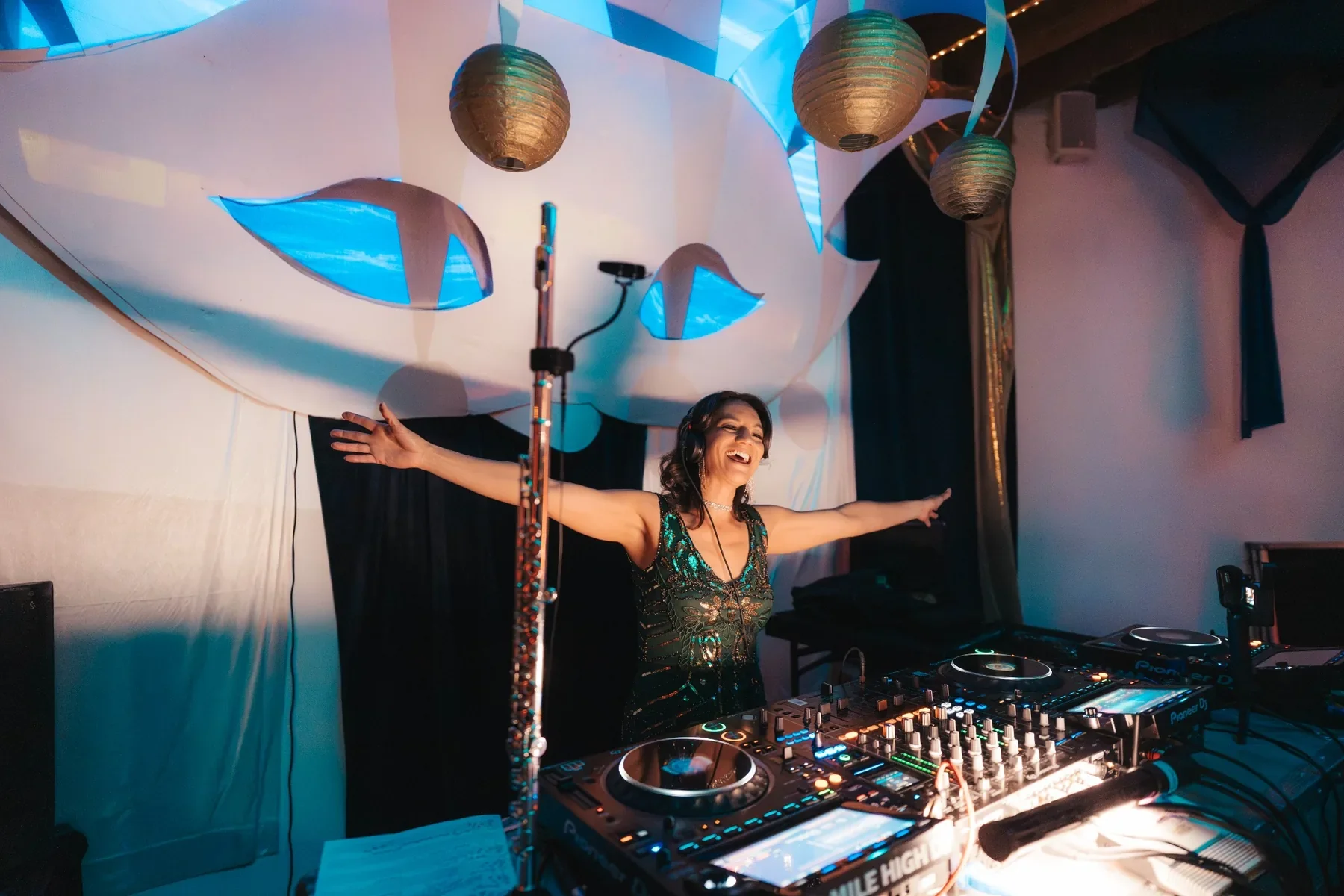 DJ Raela performs at North Star Productions' Arcana event beneath glowing suspended décor and beside a flute.
