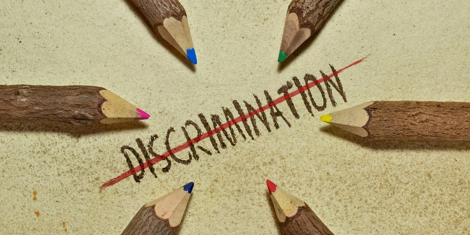 Six colored pencils pointed inward surrounding the word 'DECLINATION' crossed out with a red line on a beige surface.