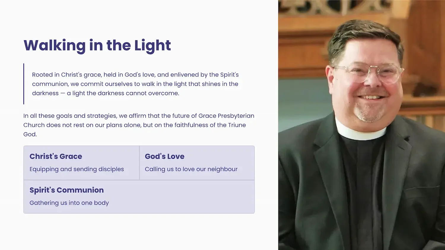 A smiling man in glasses wearing a clergy collar and suit, sitting indoors with a wooden background, next to a church-themed presentation slide titled 'Walking in the Light' that discusses Christian themes of grace, love, and the Spirit's communion.