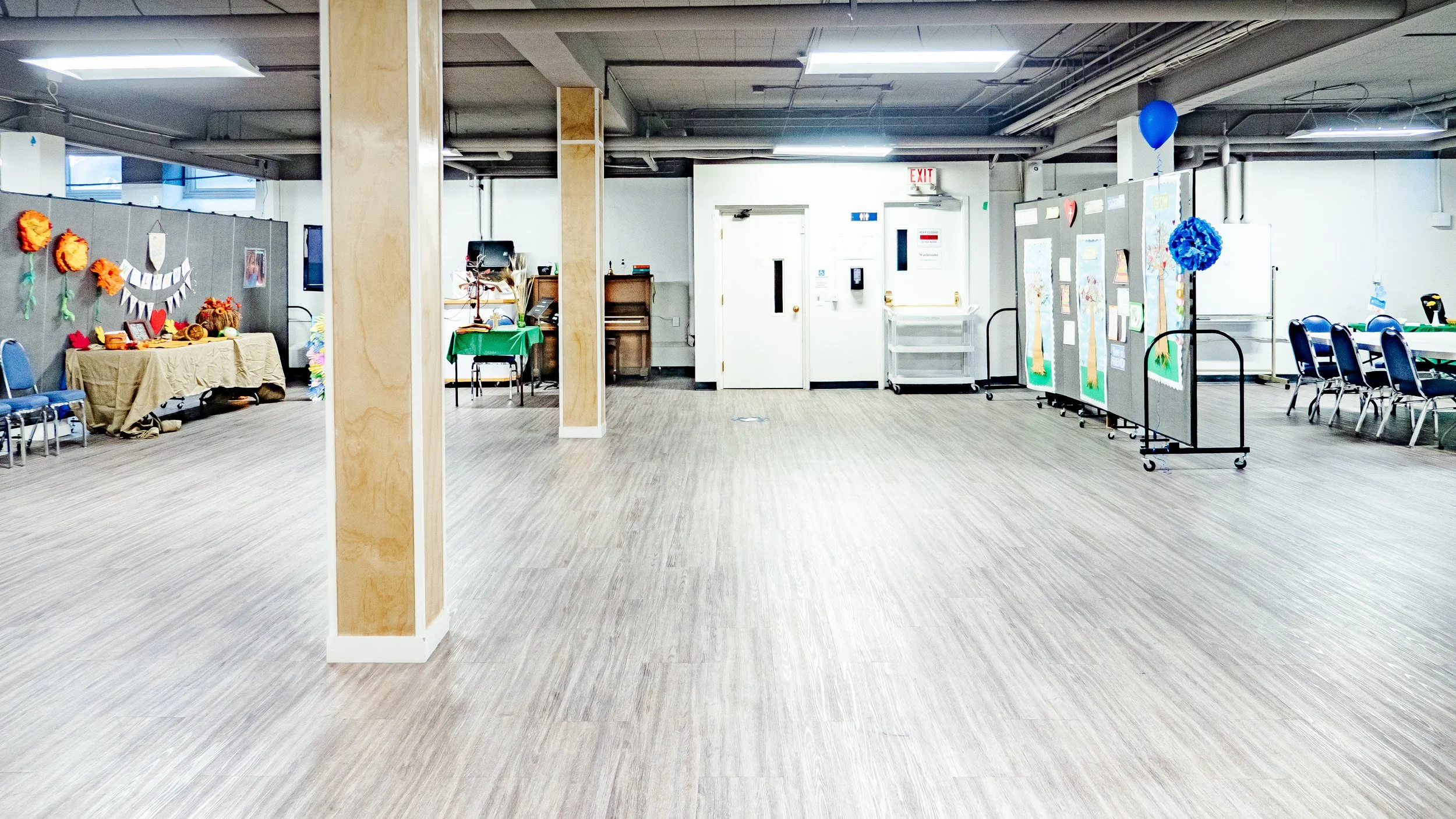 Empty room with decorated tables and display boards, possibly set up for an event or celebration.