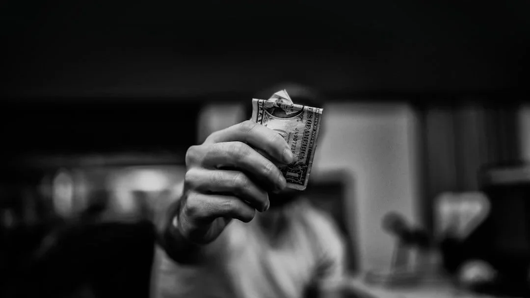 Person holding cash, representing financial enabling and family boundaries in addiction