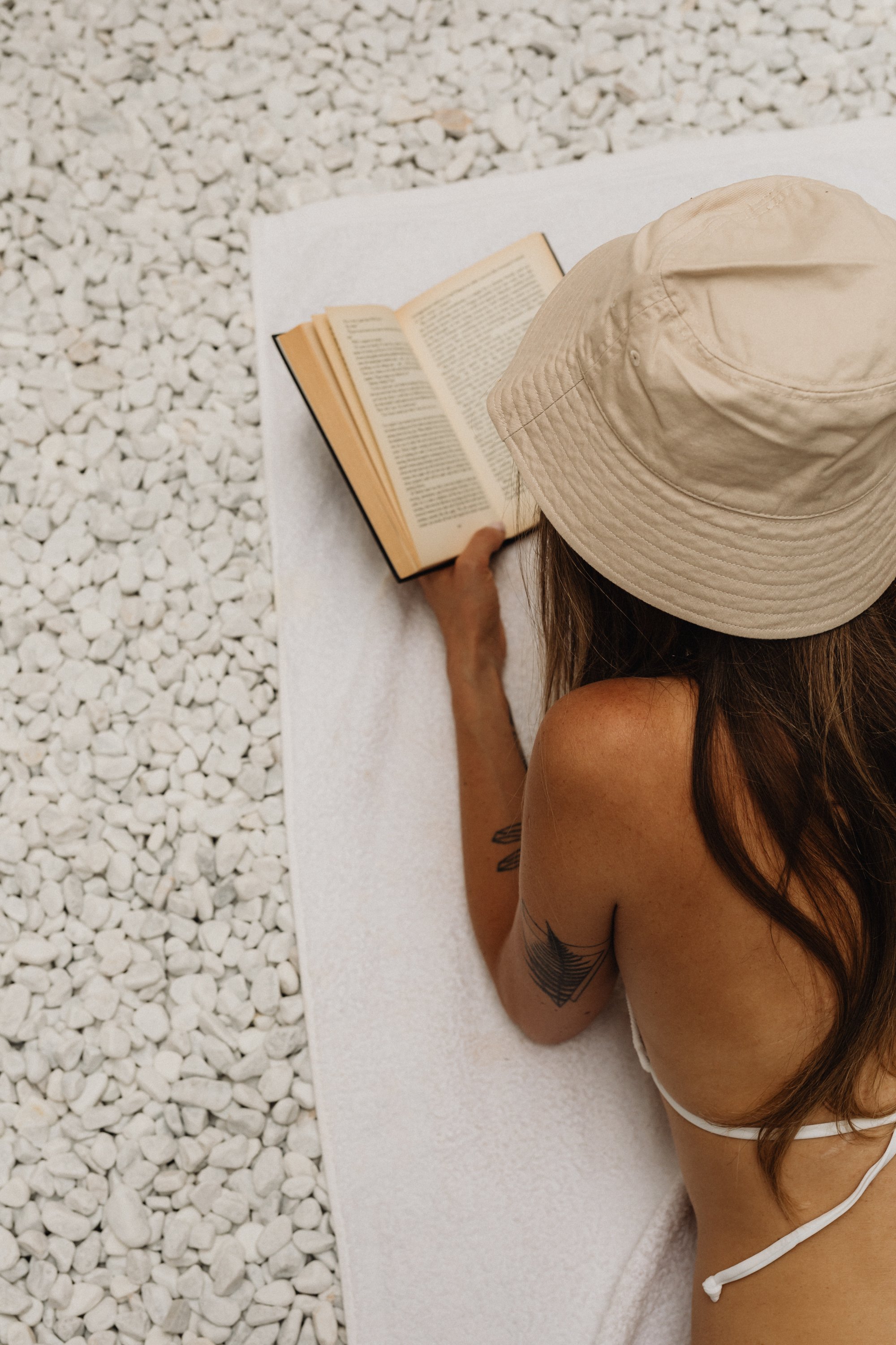 Premium Squarespace Template, Coaching Squarespace Template, Avelã Creative. Person in bikini reading a book on white stones.