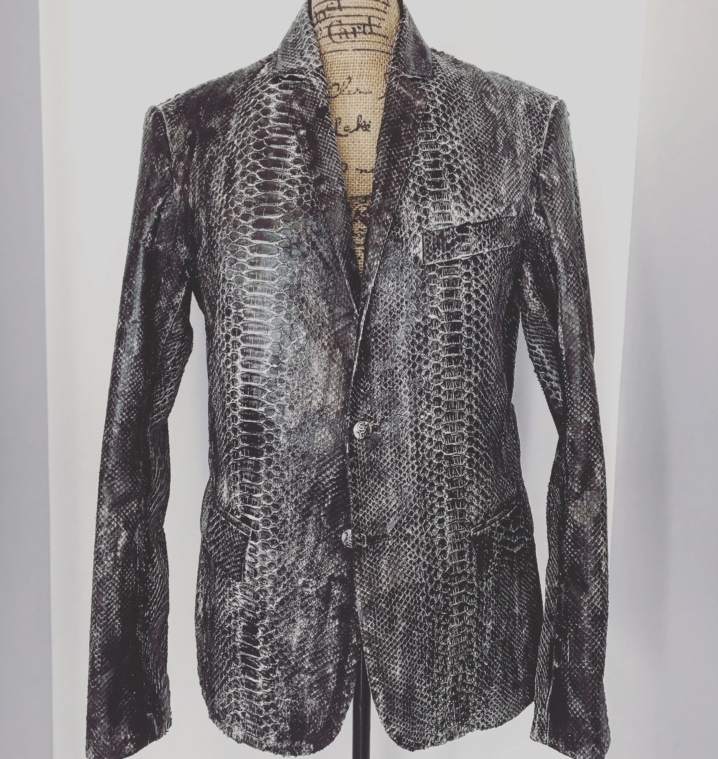 A men's blazer made of python snake skin pattern displayed on a mannequin.
