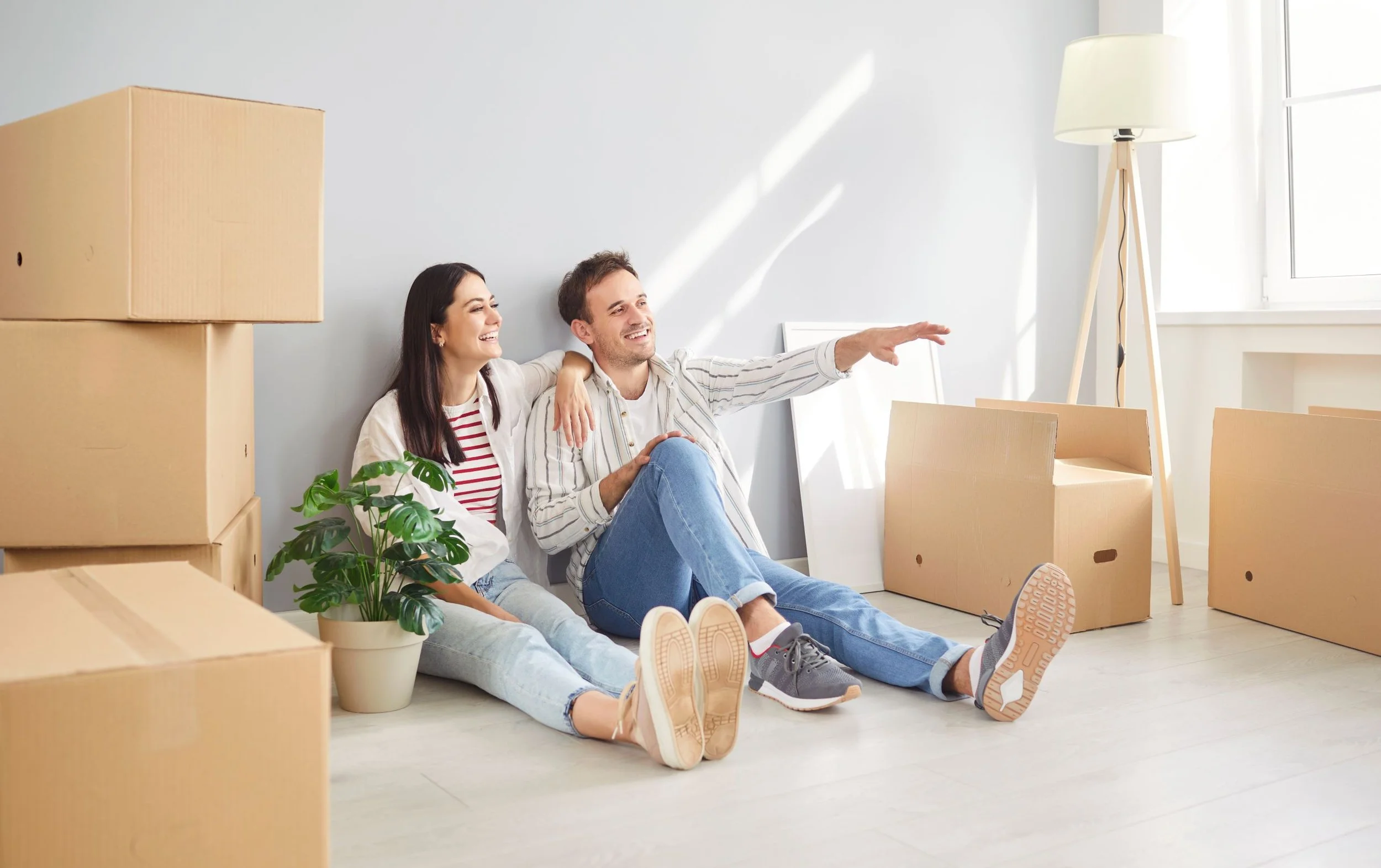 Renters taking a moment to discuss furniture plans while moving into their new home.