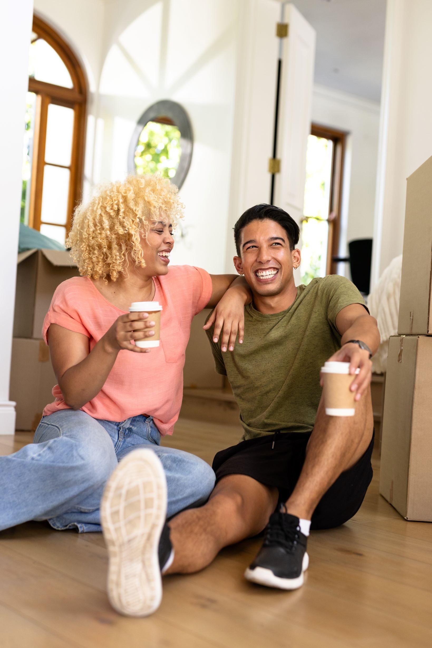 A young couple enjoying their first takeaway coffee in their new rental home.