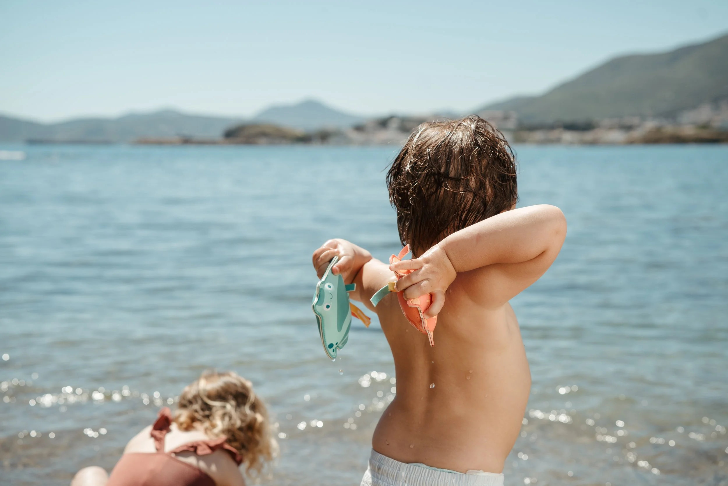 Child on a beach playing with Eurekakids water toys.