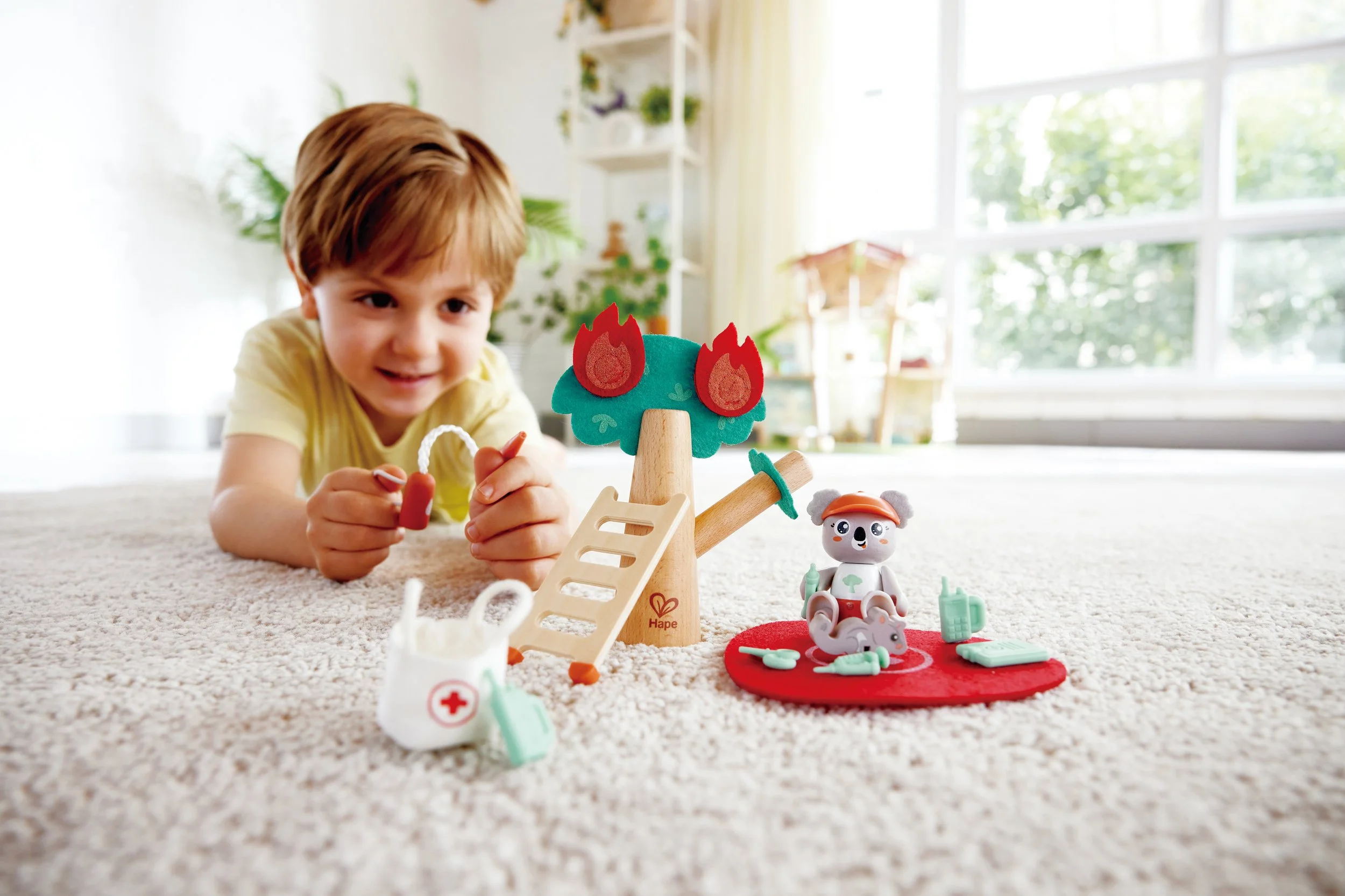 Young boy playing with Green Planet Explorers Forest Fire Rescue by Hape.