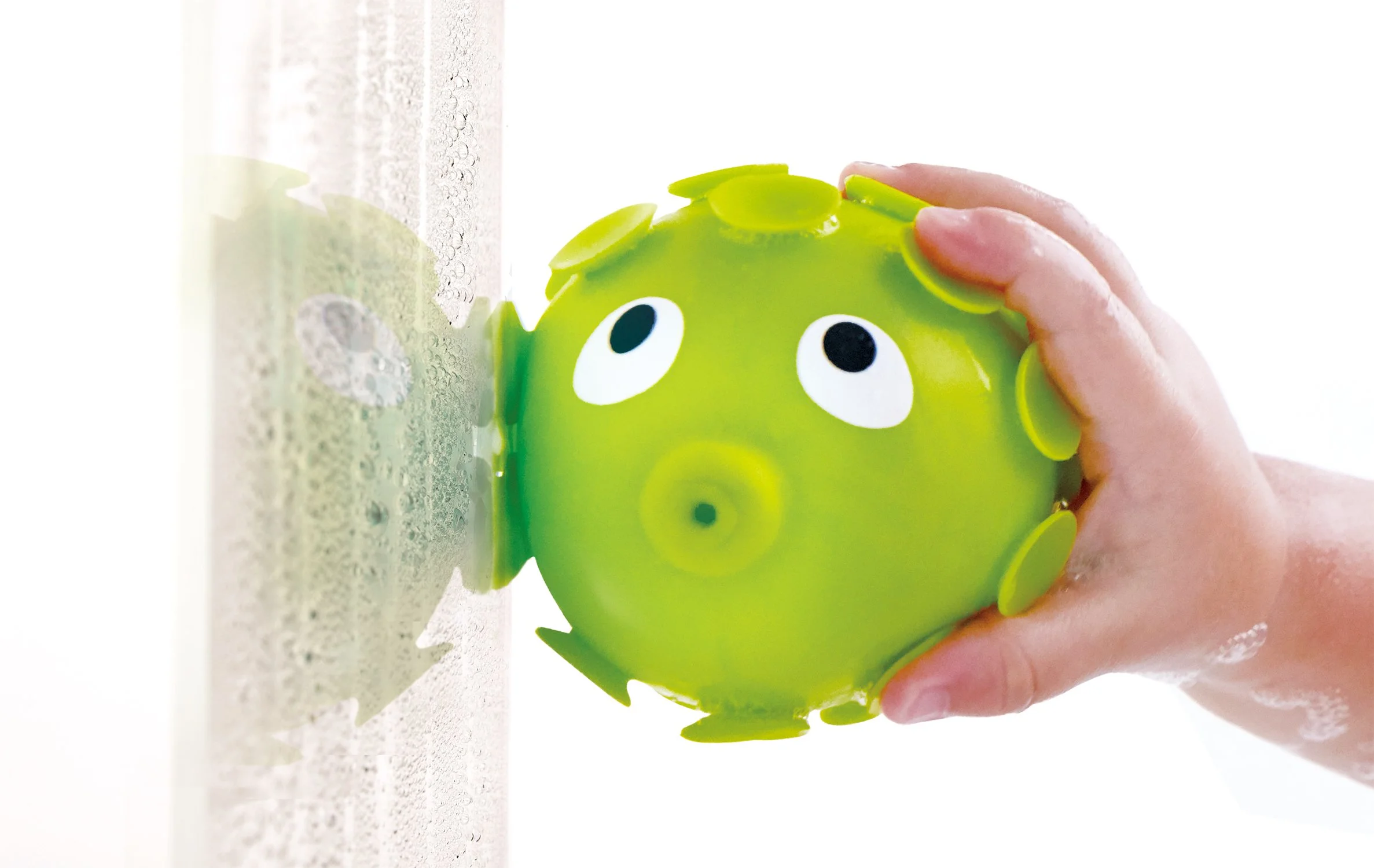 Child using "Rock pool squirter" by Hape to plsy in the bathub.