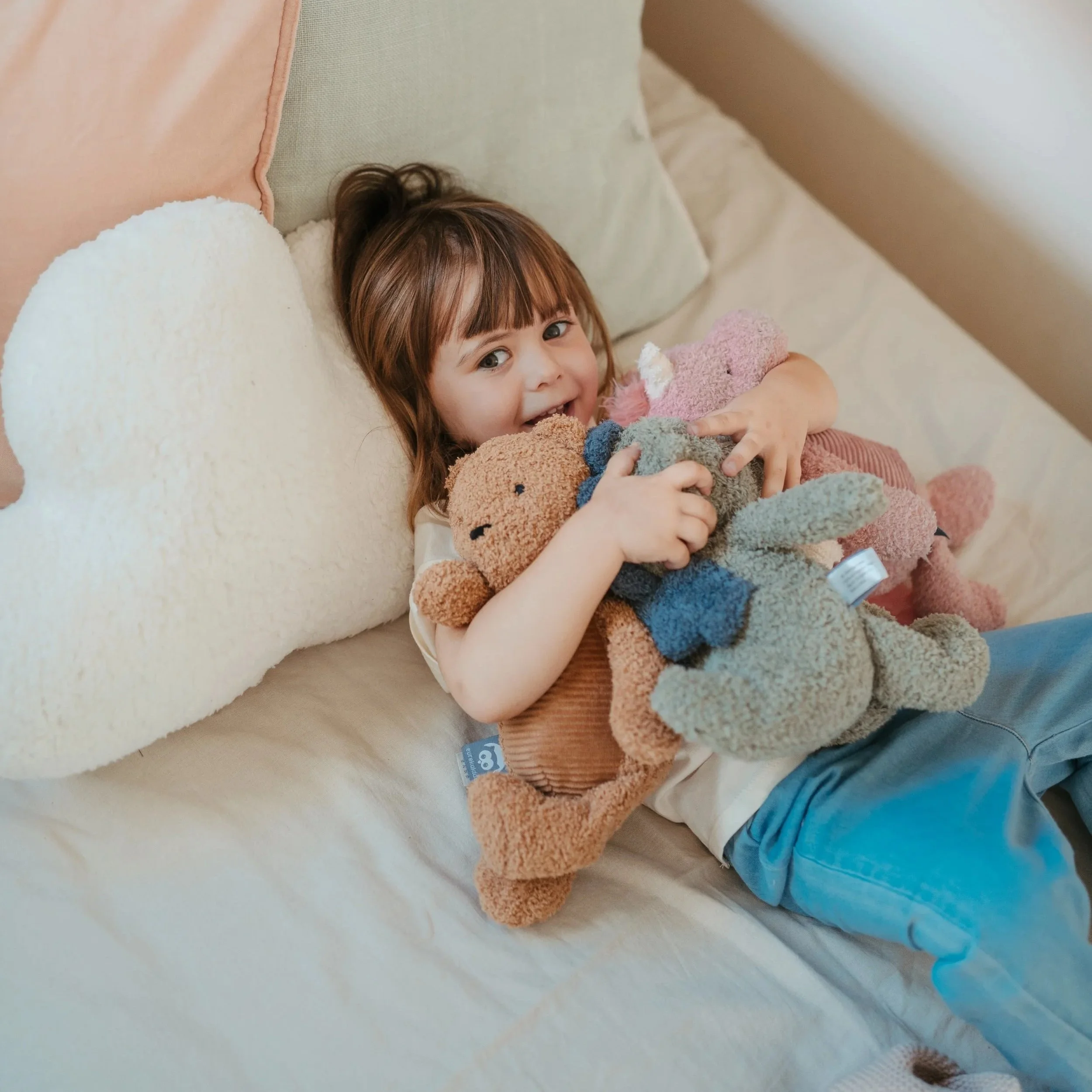 little girl clutching imaginative and soft plush toys