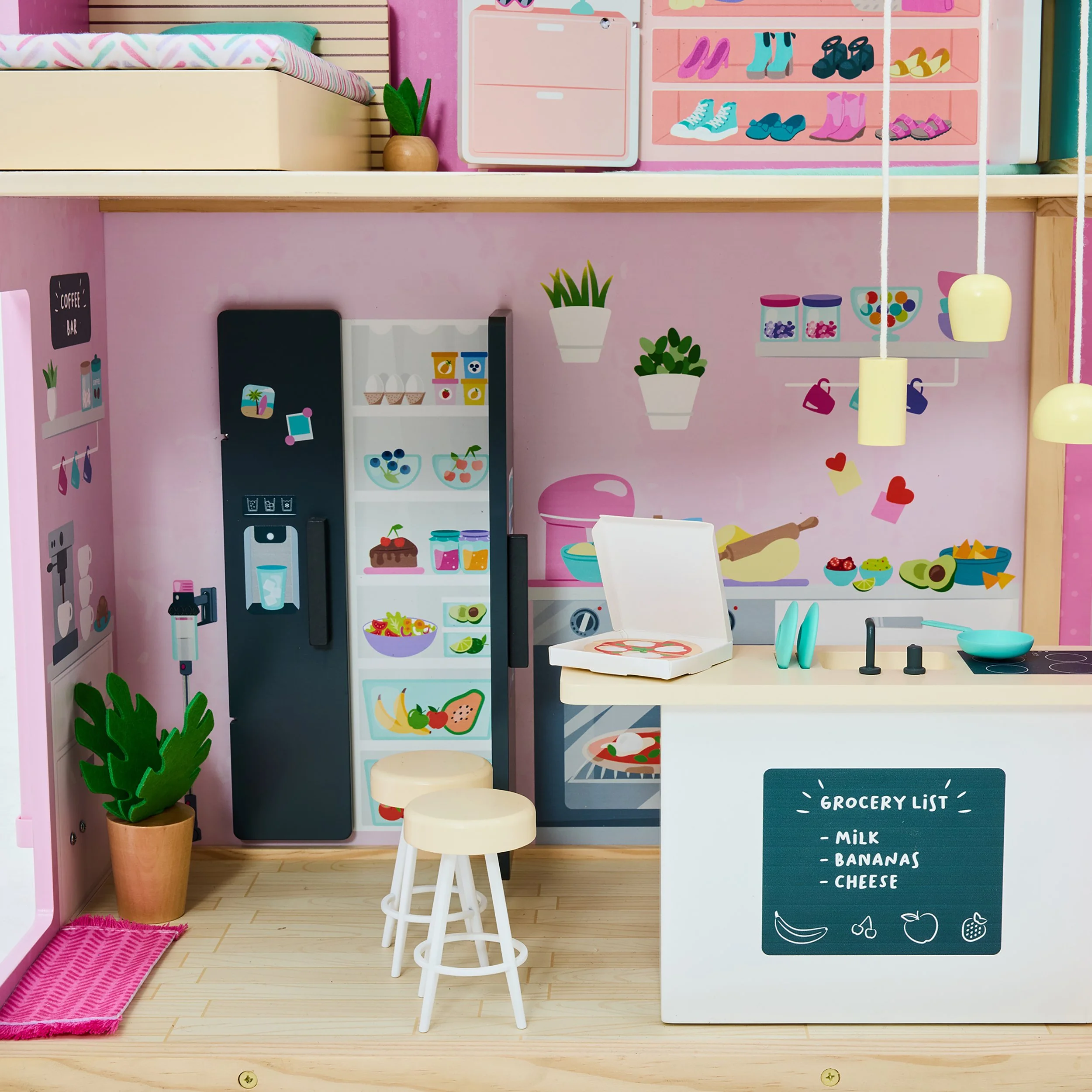 A miniature kitchen with pastel pink and white colors, featuring a refrigerator, a small kitchen island with a chalkboard grocery list, and various kitchen accessories and decor such as potted plants and hanging lamps.