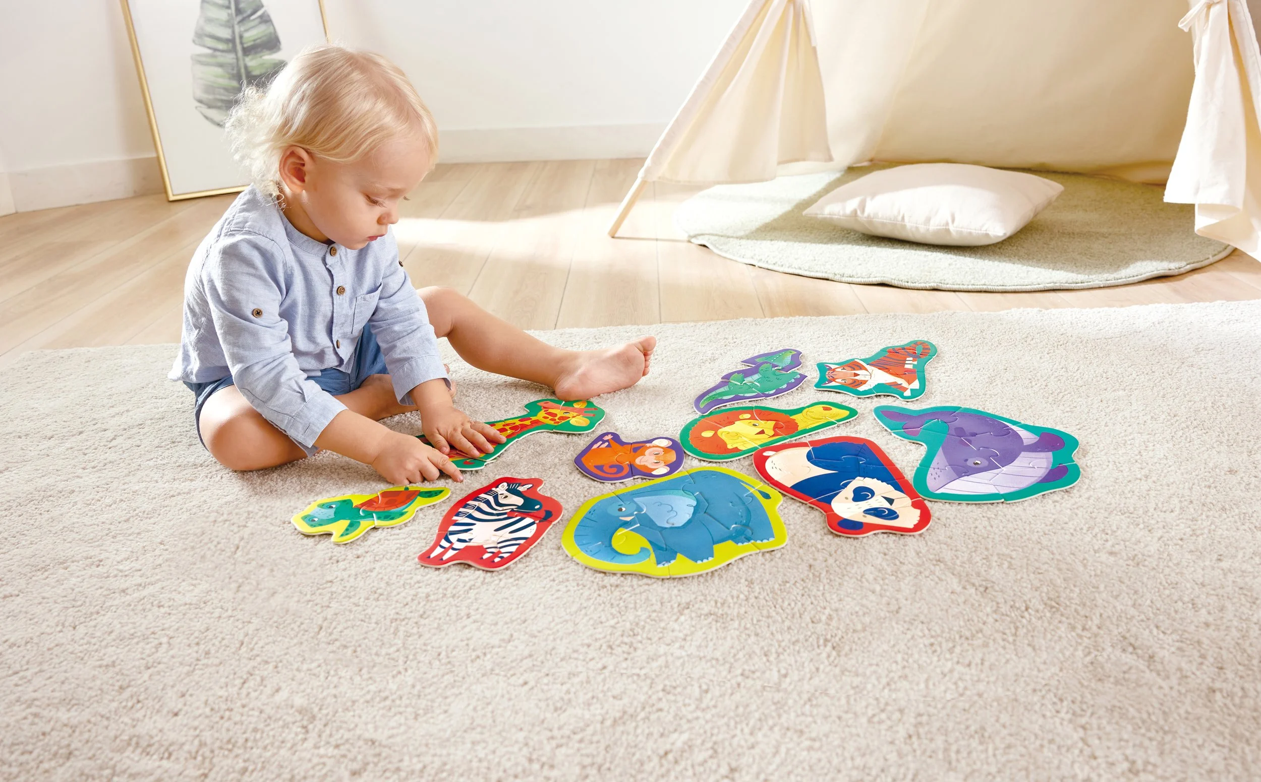 A young child playing with colorful animal-shaped Hape puzzles on a beige carpet in a well-lit room.