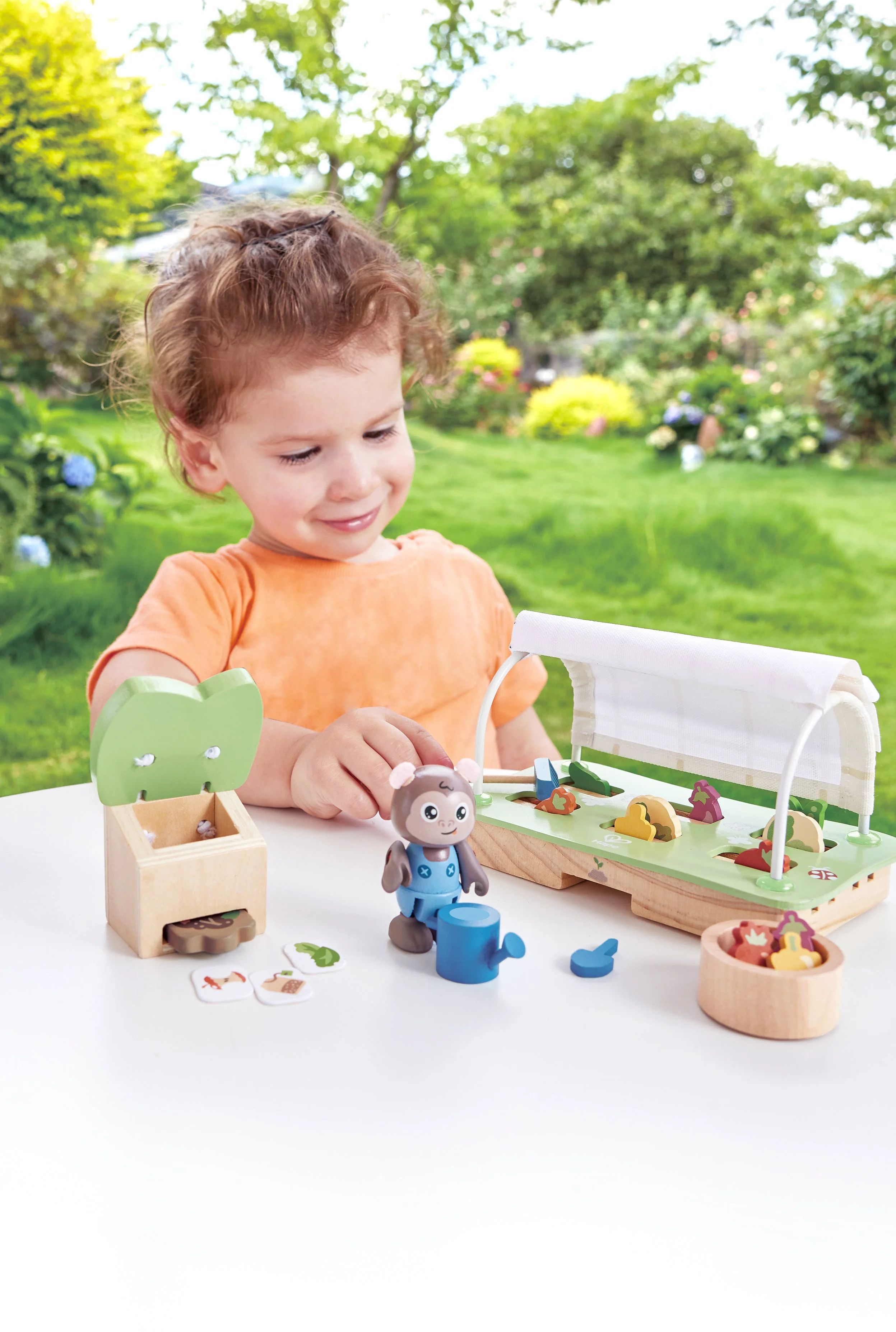 Young child playing with Green Planet Explorers Organic Greenhouse by Hape. Marco make compost from organic waste to fertilise the soil.