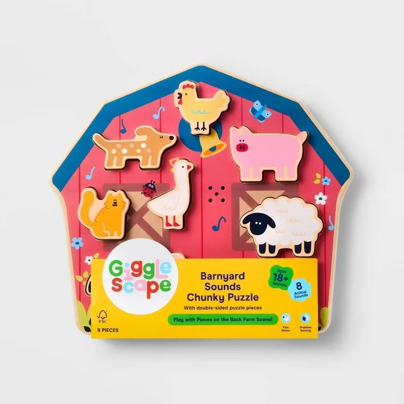 Barn-shaped educational toy box containing a wooden farm-themed puzzle with animal figures such as a chicken, pig, sheep, dog, duck, and a ladybug, designed for children aged 18 months and older. Developed for Target.