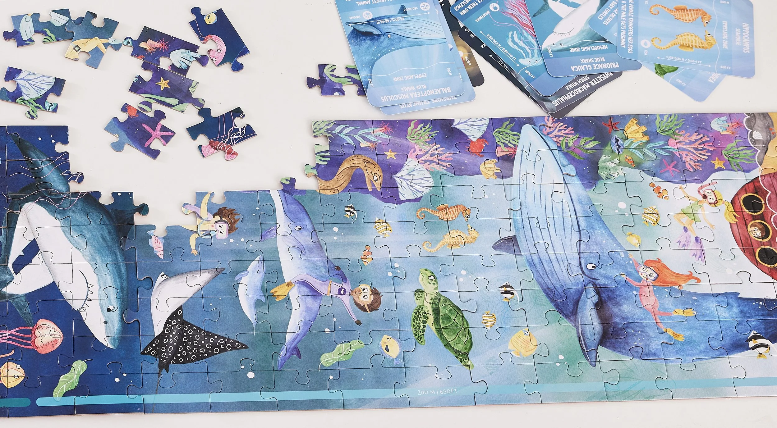 Hape puzzle depicting an underwater scene with various sea creatures, mermaids, and divers.
