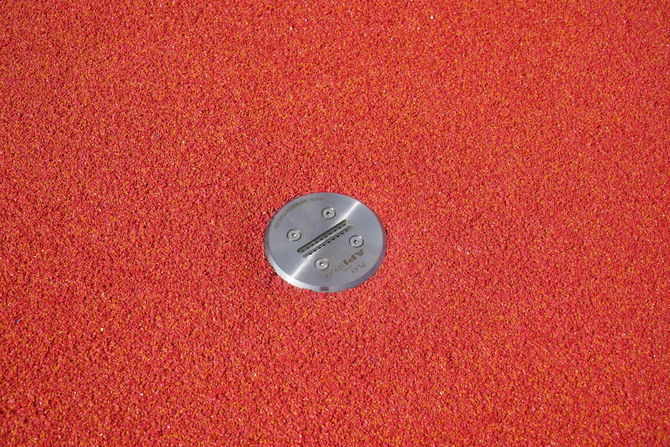 Rote Gummibeläge mit einer runden Metallplatte in der Mitte, die ein Gleit- oder Befestigungselement darstellt.