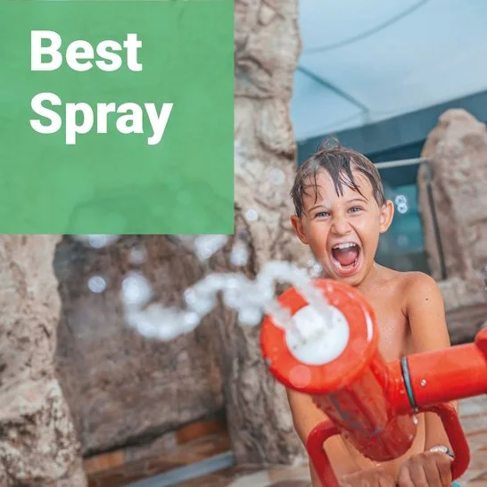 A smiling boy sprays water with a WATER FUN CANNON at Splash & SPA Tamaro in Switzerland, with rocks in the background; product category: "Best Spray"