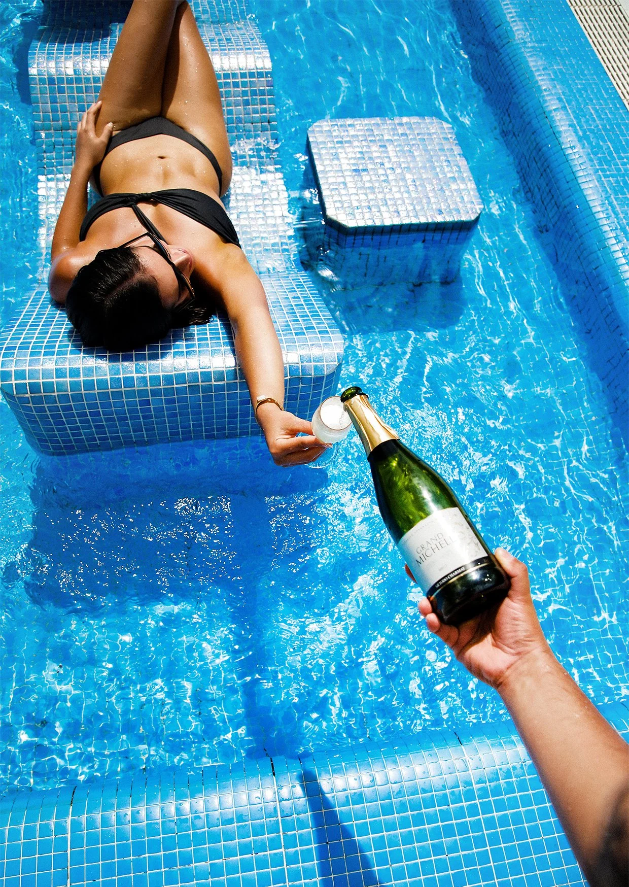 waiter serving more champage to customer who is in the pool.jpg