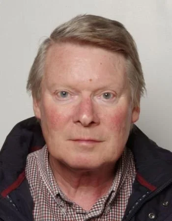 Middle-aged Paul Holt wearing a checkered shirt and a dark jacket.