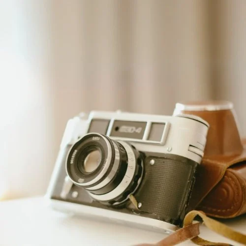 Vintage Kamera mit Lederetui auf weißem Tisch