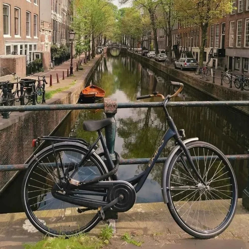 Gracht mit Fahrrad im Vordergrund in Amsterdam