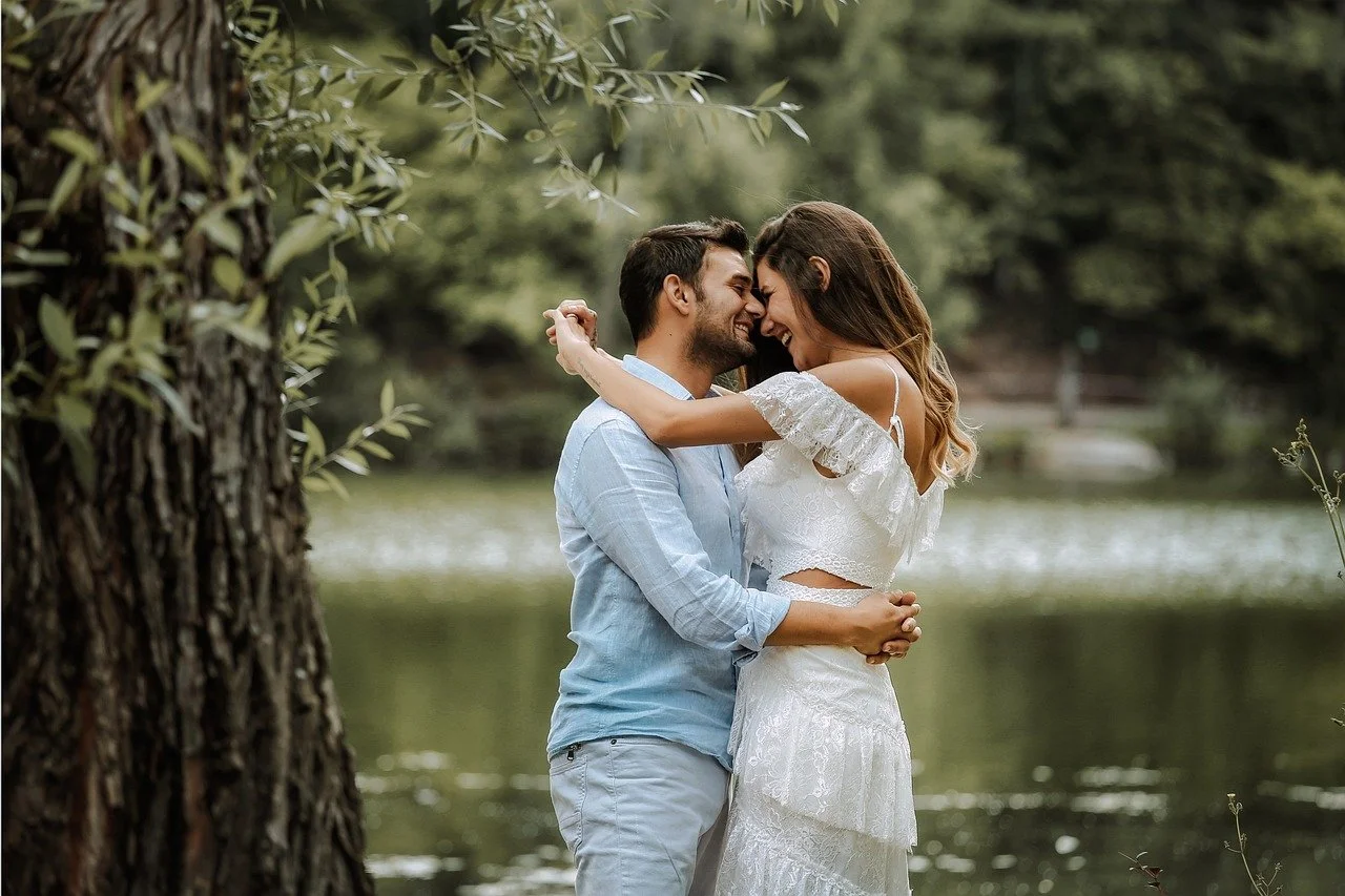 engaged couple sharing romantic embrace in beautiful woodland setting