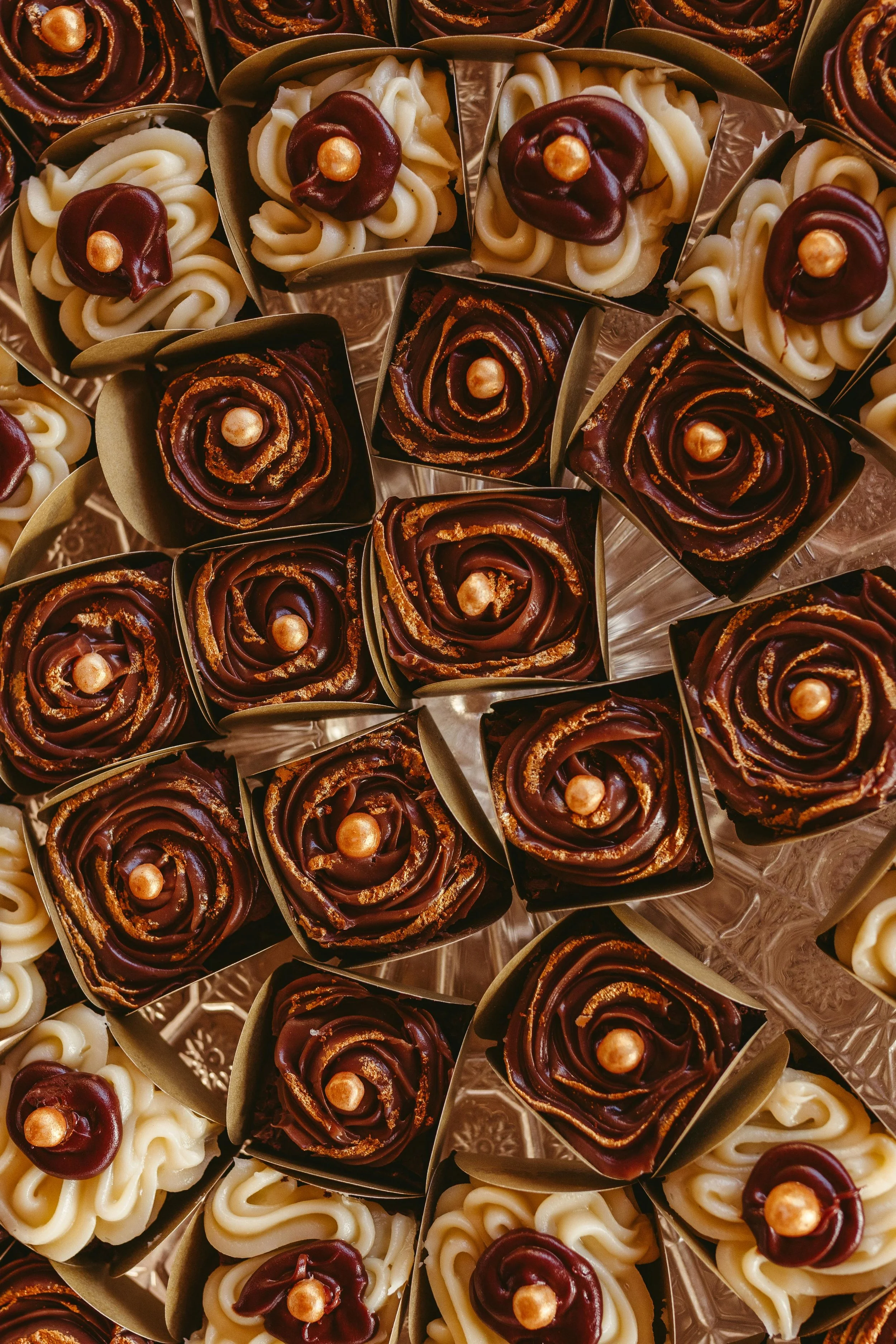 assortment of chocolates laid out in a pattern mixture of white and dark chocolate