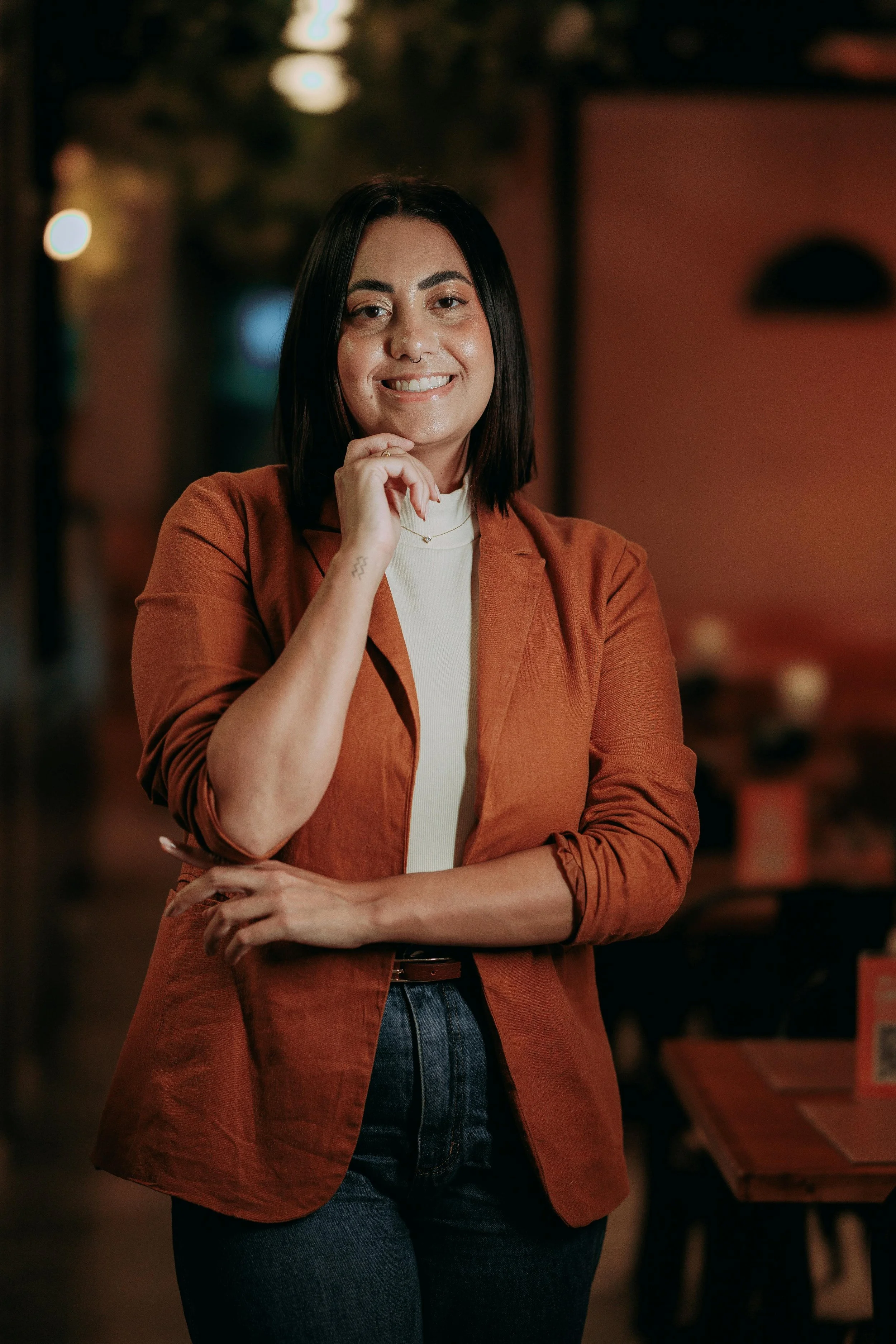 business owner stood facing the camera with head resting on hand