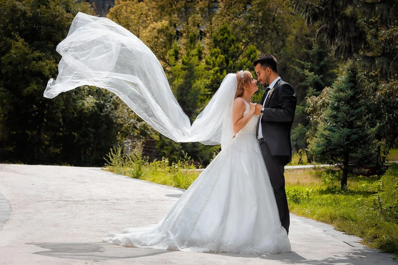 bride and groom looking at each other after ceremony with veil in the wind