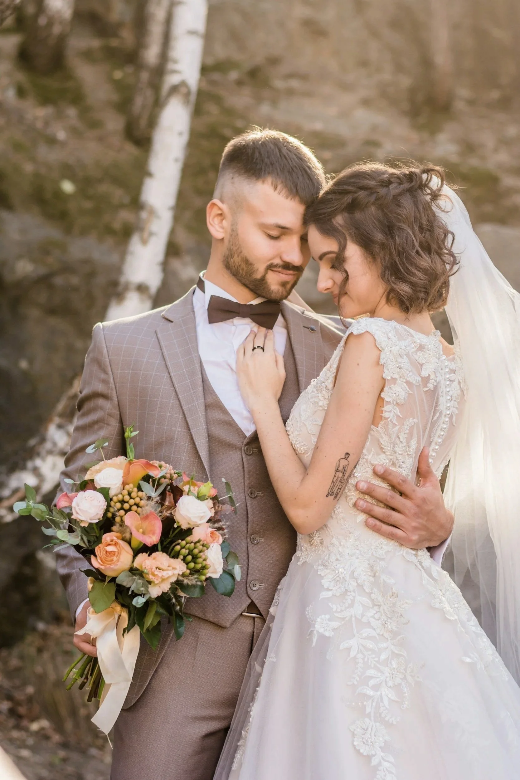 bride and groom sharing embrace with groom holding brides flowers